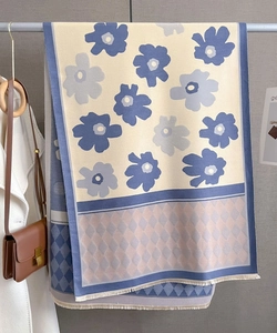 Detail of blue floral and geometric cashmere scarf with soft tassel edges