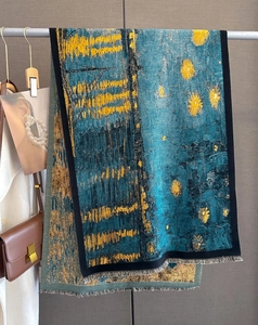 Detailed shot of artistic oil painting scarf featuring deep blue and yellow with fine tassels