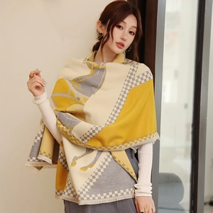 Detailed texture of thick cashmere-like scarf featuring horse pattern and fringe edge