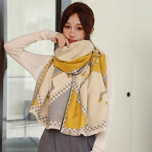 Detail of yellow and grey geometric cashmere-like scarf featuring short fringe edges