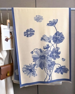 Detailed view of floral faux cashmere scarf with blue tassels and elegant pattern