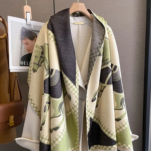 Close-up of thick cashmere-feel shawl featuring horse print, checkers, and fringe edges
