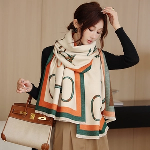 Detail of a retro geometric link pattern on a thick beige tassel scarf wrap