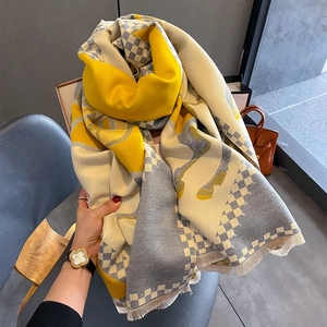 Close-up of thick cashmere-like scarf with yellow checkered pattern and horse motif detail