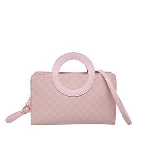 Sac à main rose avec poignée anneau et motif monogramme embossé sur fond blanc épuré
