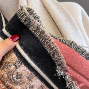Detail of vintage ethnic cashmere-feel scarf featuring red floral patterns and short tassels