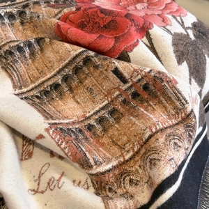 Close-up of vintage floral cashmere-like scarf with red rose prints and woven texture