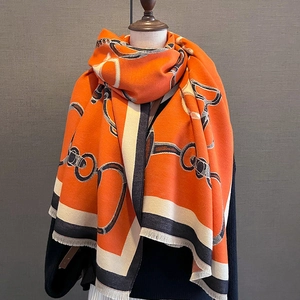 Detail of orange cashmere-like scarf showing luxury chain patterns and fringe edges