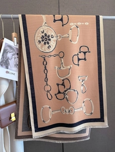 Close-up of thick cashmere feel scarf with equestrian chain patterns and fringe edges