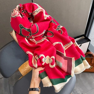 Detail of red winter shawl with equestrian chain patterns and delicate fringe edges