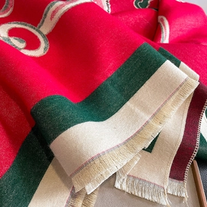 Macro shot of thick knit scarf fabric with classic red and green jacquard pattern and fringe