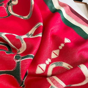 Macro shot of red cashmere-feel scarf detailing chain and stirrup patterns with sharp textures