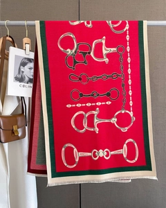 Detail of red cashmere scarf with chain pattern print and forest green contrast borders