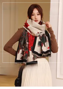 Detail of floral cashmere-like scarf with red flower print and fringe edges on a model
