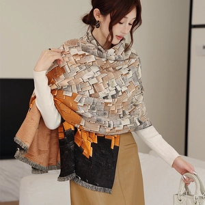 Detailed view of winter thick scarf featuring orange geometric patterns and tassel edges