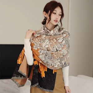 Detail of soft cashmere-like scarf showing geometric color blocks and fine tassel edges