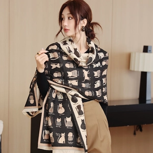 Close-up of thick cat pattern scarf with tassels in dark grey and beige tones