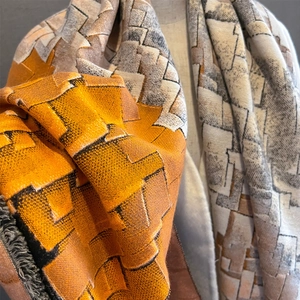 Detail of color-block geometric scarf with thick fleece lining and soft cashmere texture
