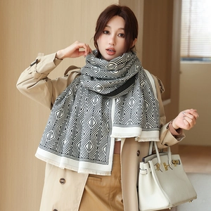 Detail of classic black and white geometric pattern scarf with natural fringe edges