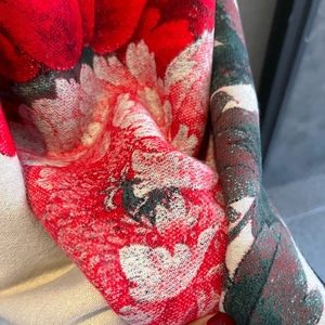 Close-up of red floral cashmere scarf with black deer silhouette and premium knit texture