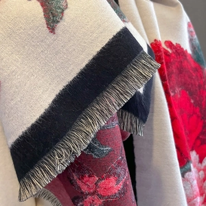 Close-up of vintage floral print cashmere scarf featuring red flowers and grey fringe