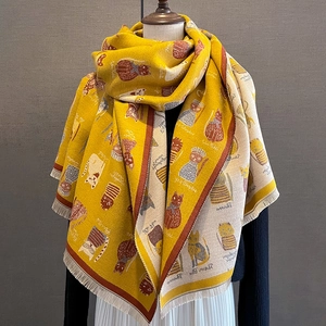 Detail of ginger cat pattern scarf with soft knit texture and fringe tassels