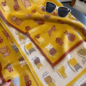 Detailed view of ginger yellow winter scarf featuring cat jacquard and soft fringe edges