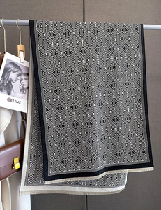 Close-up of black and white geometric knit scarf with delicate short fringe detail