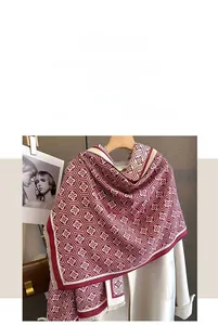 Detailansicht eines Winter-Schals mit rotem Geometriemuster und weichen Quastenkanten