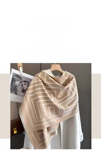 Detail of beige cashmere scarf with geometric lines and delicate fringe trim