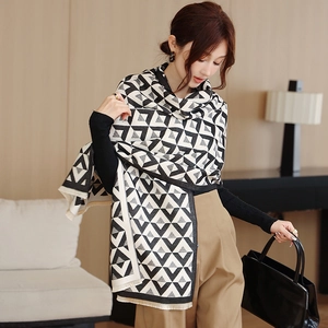 Close-up of black and white geometric pattern knit scarf with fine tassel fringe details
