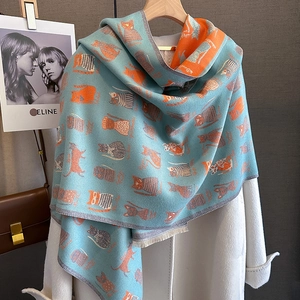 Detailed knit texture and cartoon cat pattern on a light blue thick winter scarf