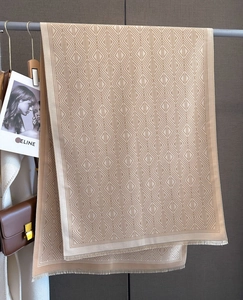 Detail of diamond jacquard pattern on a beige winter scarf with soft fringed edges