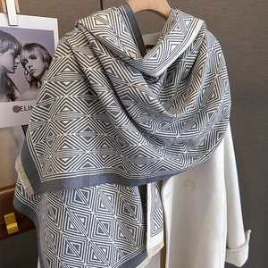 Detail of grey and white geometric diamond pattern scarf with soft fringe edges