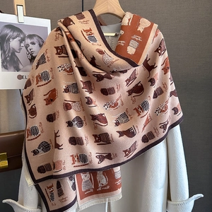 Detail of cashmere-like scarf showing cute cat patterns and delicate fringe edges