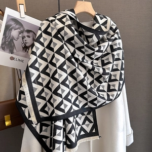 Close-up of black and white geometric pattern scarf with elegant white fringe details