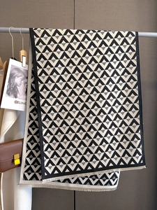 Detailed view of geometric triangle knit scarf with fringe edge on studio display