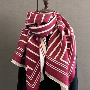 Fashionable cashmere-like scarf with geometric patterns and short tassels on a mannequin