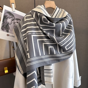 Detail of grey geometric cashmere scarf with fringe and take care of yourself text