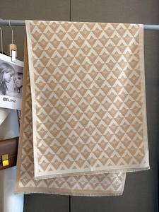 Macro detail of geometric jacquard pattern and fringe edge on cashmere-feel scarf