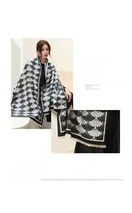 Detail of soft faux cashmere scarf with black and white scallop jacquard and fringe edges