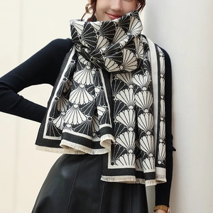 Detail of a thick black and white scallop pattern shawl with delicate fringed edges