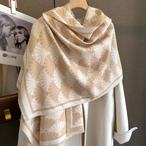 Detail of scallop jacquard pattern and soft fringe on a beige cashmere-feel shawl