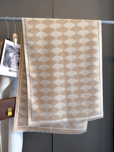 Detail of beige scallop pattern winter scarf with soft fringes and thick texture
