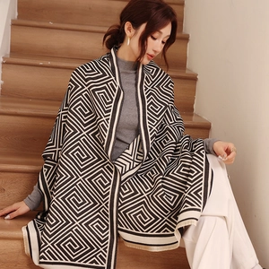 Detailansicht eines Strickschals mit geometrischem Muster und feinen Fransen am Saum