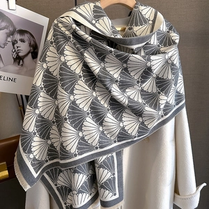 Detailed view of grey and white shell-patterned scarf with delicate fringe edges