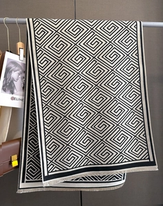 Nahaufnahme des geometrischen Mäandermusters auf dem beige-schwarzen Kaschmirschal