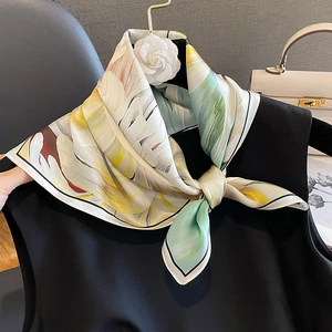 Carré en soie élégant à motif floral noué en nœud sur un haut noir avec sac et camélia