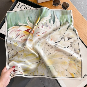 Carré en soie élégant avec motif floral et texture lisse sur table en bois