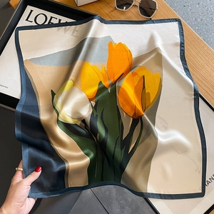Eleganter Seidenschal mit gelben Tulpen und blauem Rand auf schlichtem Hintergrund
